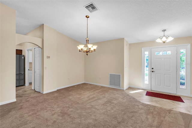 carpeted foyer featuring a textured ceiling