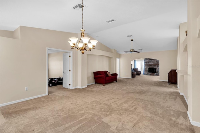 unfurnished room featuring lofted ceiling, light carpet, a stone fireplace, and ceiling fan with notable chandelier