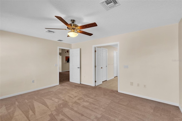 unfurnished room with light carpet, a textured ceiling, and ceiling fan