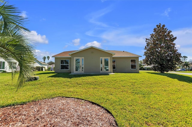 rear view of property featuring a lawn