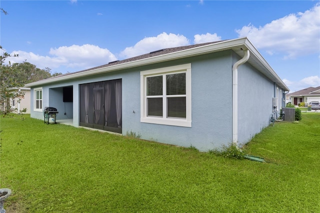 rear view of property with cooling unit and a lawn