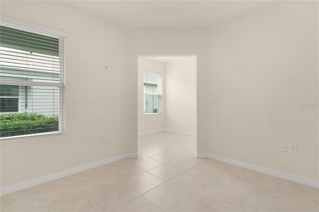 tiled empty room featuring plenty of natural light