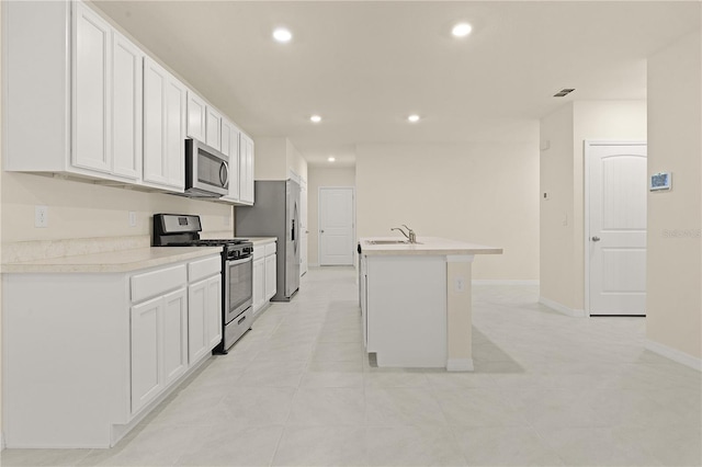 kitchen featuring appliances with stainless steel finishes, sink, a center island with sink, and white cabinets