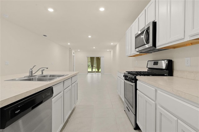 kitchen with white cabinetry, sink, light tile patterned flooring, and appliances with stainless steel finishes