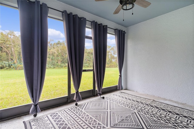 unfurnished sunroom featuring ceiling fan