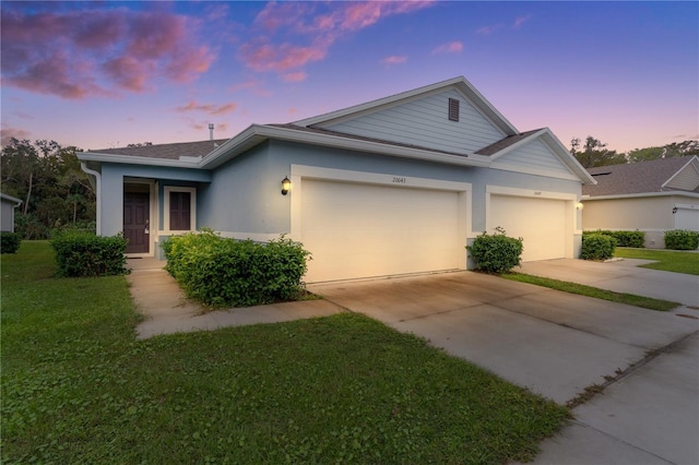 view of front of home with a yard and a garage