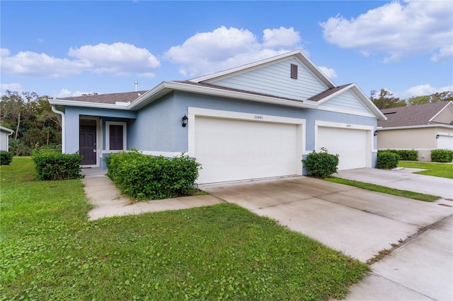 ranch-style home with a garage and a front lawn