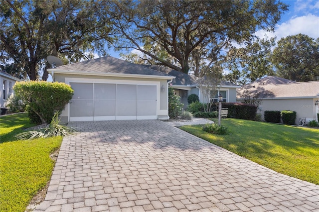 single story home featuring a garage, decorative driveway, stucco siding, and a front yard