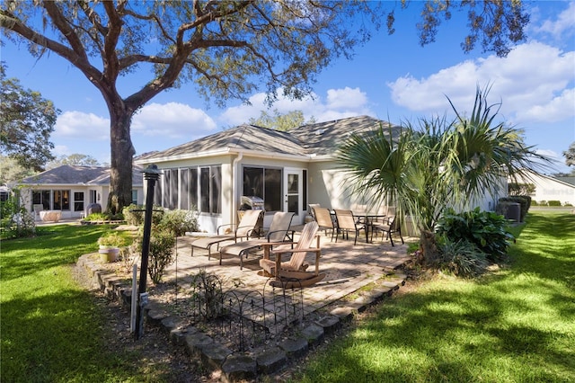 back of house featuring a patio, a lawn, and a sunroom