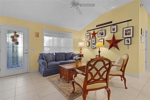 living room featuring lofted ceiling, a textured ceiling, ceiling fan, and light tile patterned floors