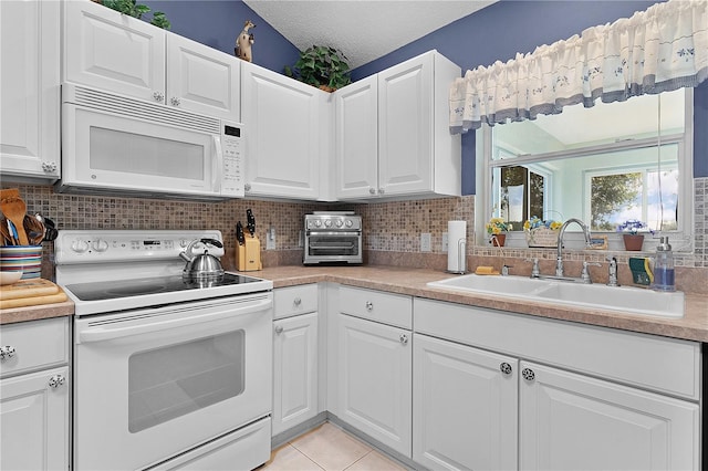 kitchen featuring white cabinetry, a textured ceiling, sink, and white appliances