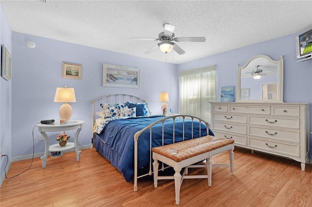 bedroom featuring light hardwood / wood-style floors, a textured ceiling, and ceiling fan