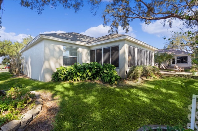 view of home's exterior featuring a yard and a sunroom