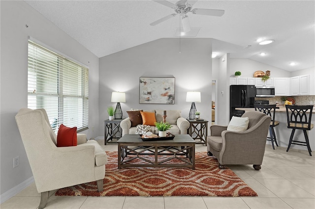 living room featuring vaulted ceiling, light tile patterned floors, and a ceiling fan