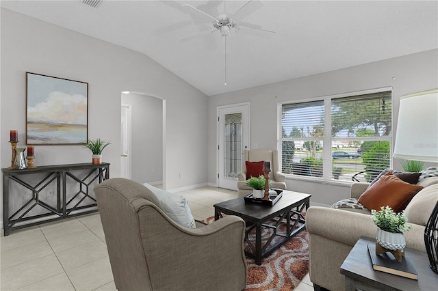 living area with light tile patterned floors, a ceiling fan, baseboards, lofted ceiling, and arched walkways