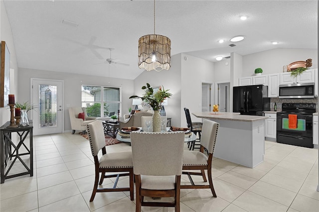 dining area with visible vents, ceiling fan with notable chandelier, a textured ceiling, light tile patterned floors, and lofted ceiling