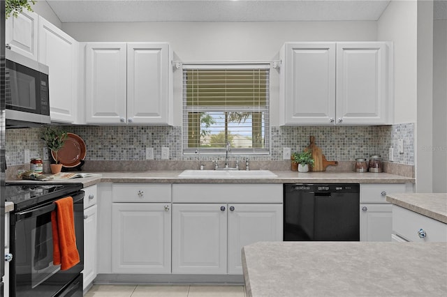 kitchen featuring a sink, tasteful backsplash, black appliances, and light countertops