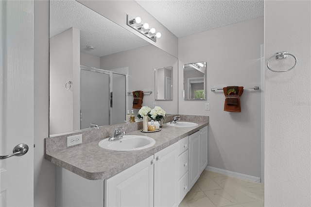 bathroom with marble finish floor, a textured ceiling, and a sink