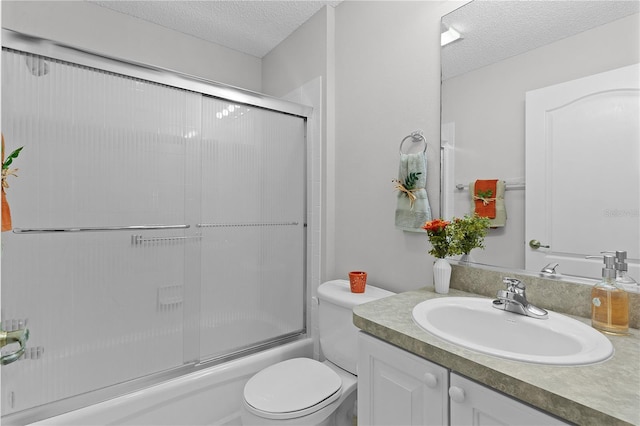 full bathroom with vanity, enclosed tub / shower combo, toilet, and a textured ceiling