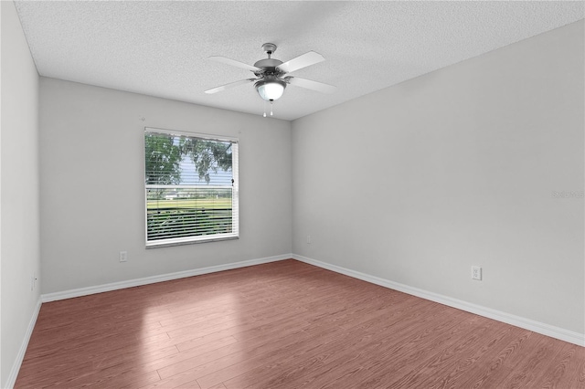 unfurnished room featuring baseboards, a textured ceiling, ceiling fan, and wood finished floors