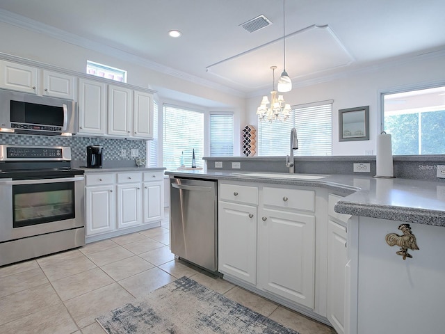 kitchen featuring appliances with stainless steel finishes, white cabinets, and a healthy amount of sunlight