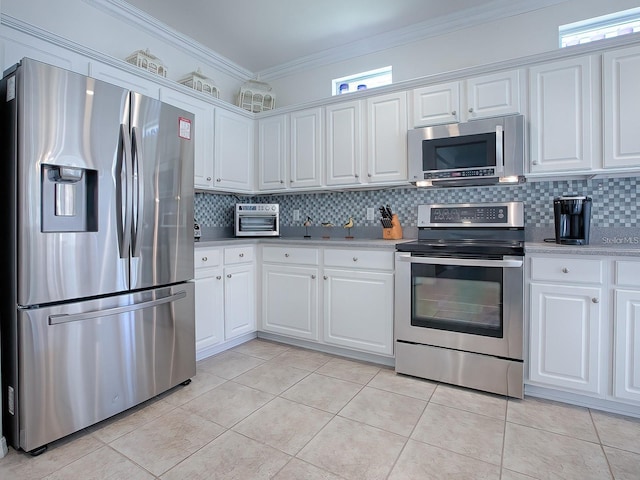 kitchen with white cabinetry, stainless steel appliances, ornamental molding, and a healthy amount of sunlight