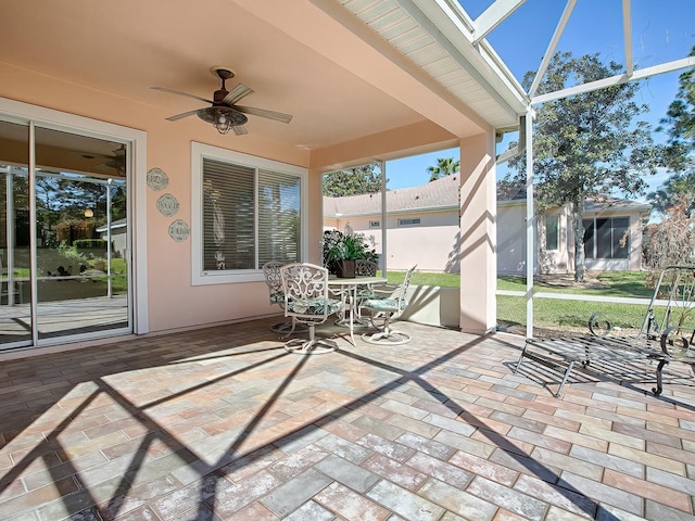 unfurnished sunroom featuring ceiling fan