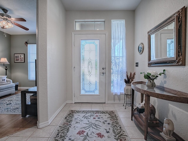 foyer entrance with ceiling fan and light hardwood / wood-style flooring