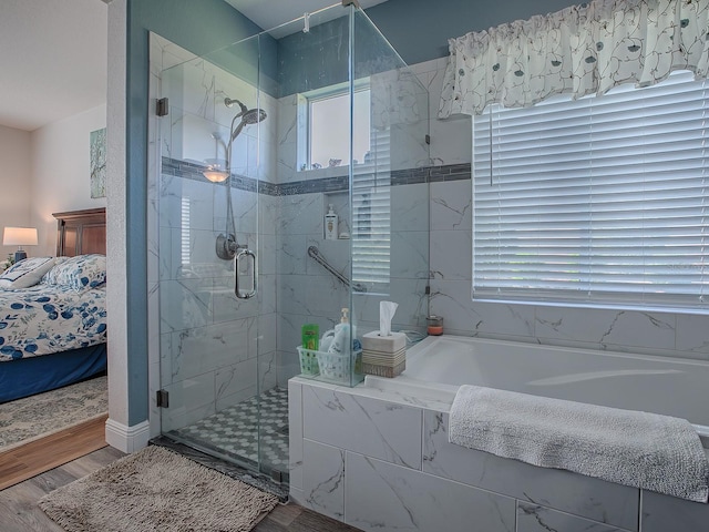 bathroom featuring hardwood / wood-style flooring, independent shower and bath, and a wealth of natural light