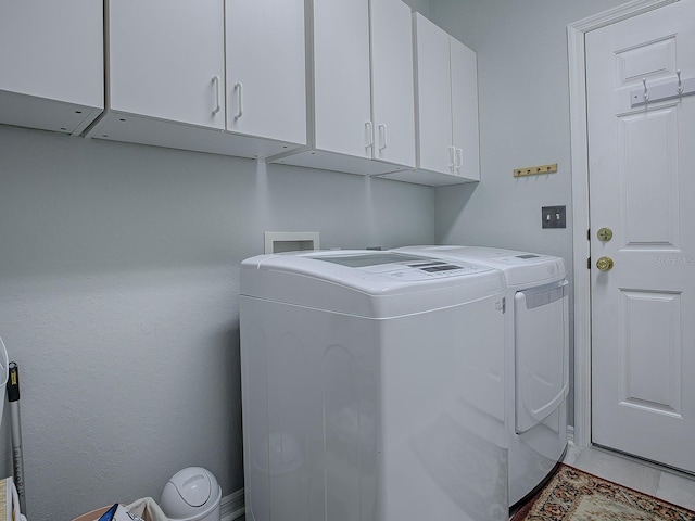 laundry area with washer and dryer and cabinets