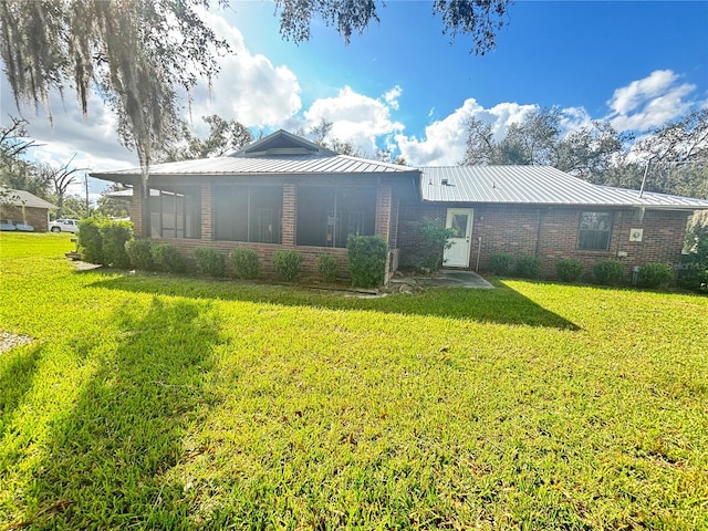 rear view of property featuring a lawn