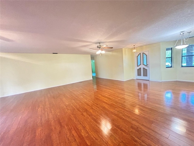 spare room with a textured ceiling, wood-type flooring, and ceiling fan