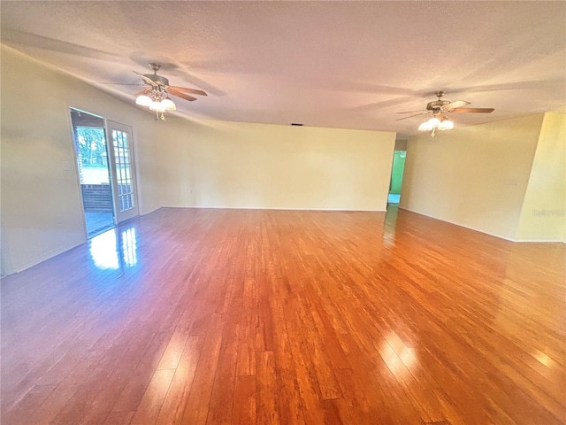 spare room with hardwood / wood-style floors, a textured ceiling, and ceiling fan