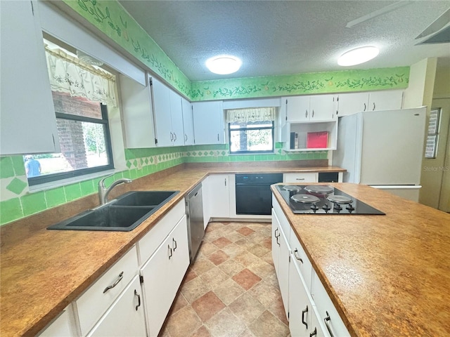 kitchen featuring a wealth of natural light, sink, black appliances, and white cabinetry