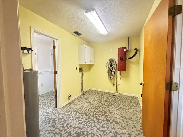 washroom featuring hookup for a washing machine, electric dryer hookup, a textured ceiling, and cabinets