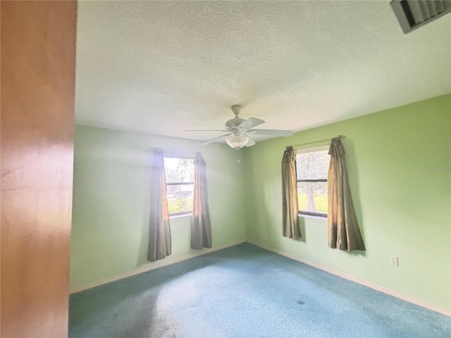 empty room with a textured ceiling, carpet, and ceiling fan