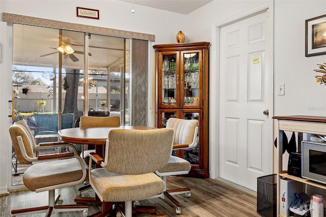 dining space featuring wood-type flooring and ceiling fan