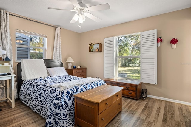 bedroom with light hardwood / wood-style floors, multiple windows, and ceiling fan