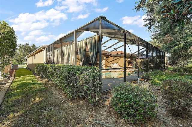 view of side of home featuring glass enclosure