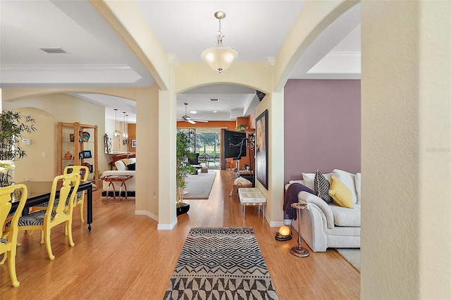 foyer with ornamental molding, light hardwood / wood-style flooring, and ceiling fan