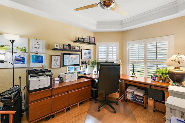 home office featuring ceiling fan, a raised ceiling, wood-type flooring, and ornamental molding