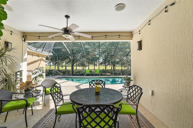 view of patio featuring ceiling fan and a lanai