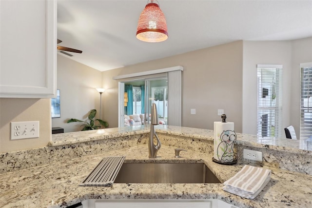 kitchen with white cabinetry, light stone countertops, sink, and a healthy amount of sunlight