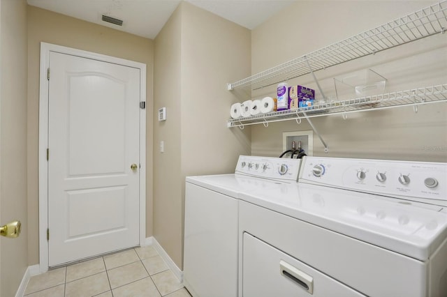 laundry area with light tile patterned floors and washer and dryer