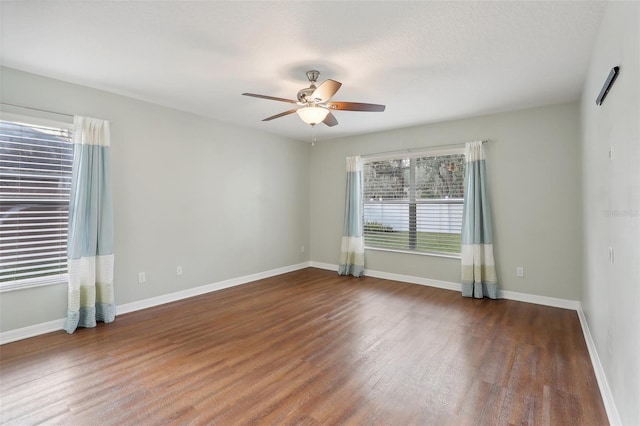 unfurnished room featuring ceiling fan and dark wood-type flooring