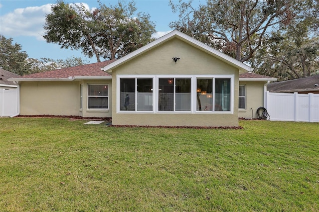 back of house with a lawn