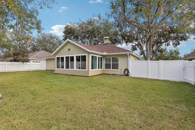 back of house featuring a sunroom and a yard