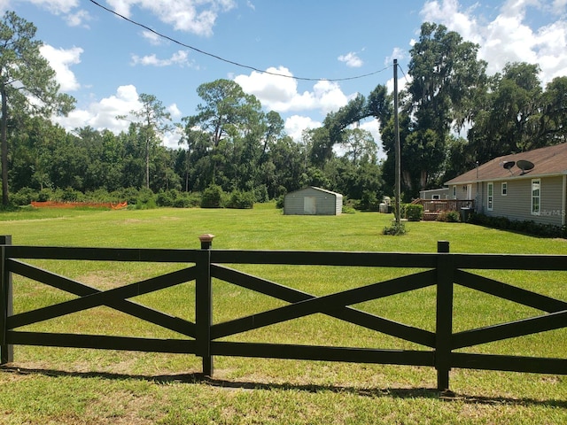 view of gate with a storage shed and a lawn