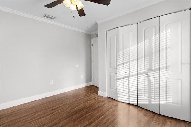 unfurnished bedroom with ornamental molding, a closet, hardwood / wood-style floors, and ceiling fan