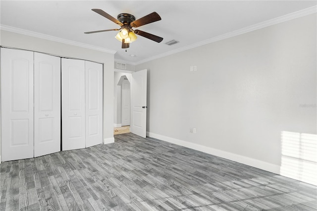 unfurnished bedroom with a closet, ornamental molding, light wood-type flooring, and ceiling fan